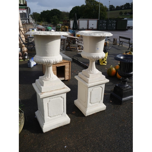 94 - PAIR OF CAST IRON URNS ON CONCRETE BASES