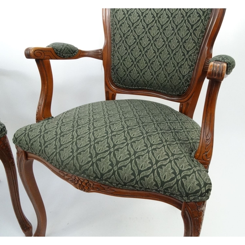 4 - Pair of carved mahogany elbow chairs with green floral upholstery