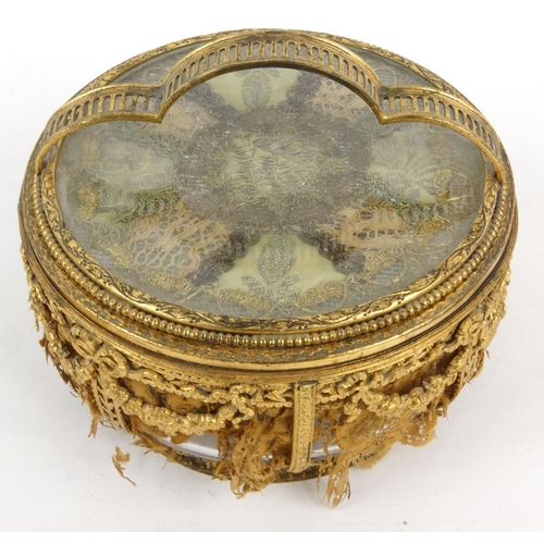 16 - French pierced gilt metal and glass powder bowl with bow and swag design inset with lace, 15cm tall