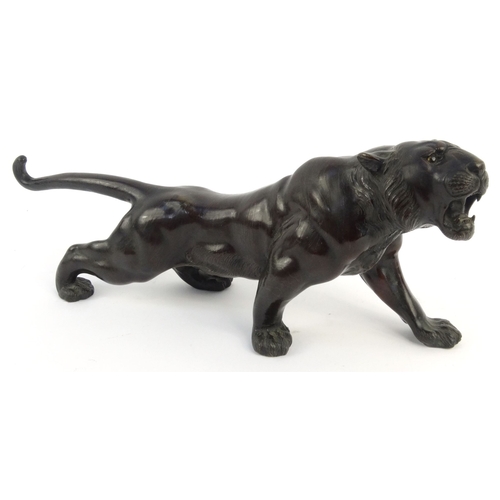 576 - Oriental Japanese bronze study of a tiger with beaded glass eyes, signature mark to belly, 46cm diam... 