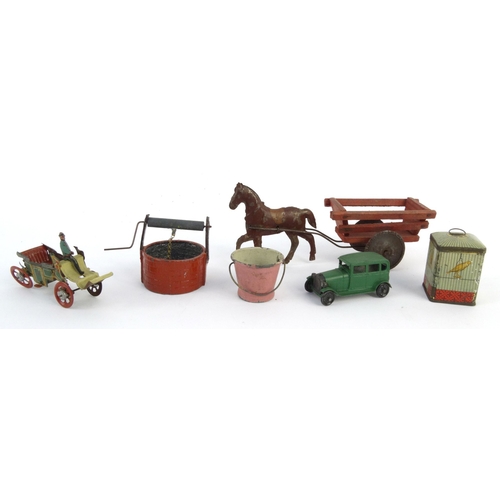 552 - Assorted tinplate and die cast toys including birdcage, horsedrawn wagon and a wishing well, the lar... 