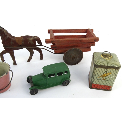 552 - Assorted tinplate and die cast toys including birdcage, horsedrawn wagon and a wishing well, the lar... 