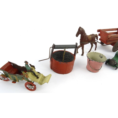 552 - Assorted tinplate and die cast toys including birdcage, horsedrawn wagon and a wishing well, the lar... 