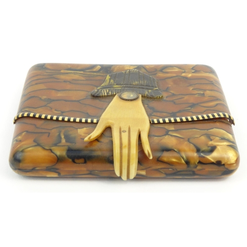 98 - Lady's Art Deco plastic cigarette case modelled as a clutch bag with hand, the clasp marked 'SWN', 9... 