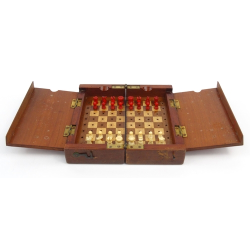 570 - Mahogany folding travelling boxed chess set, 18cm square