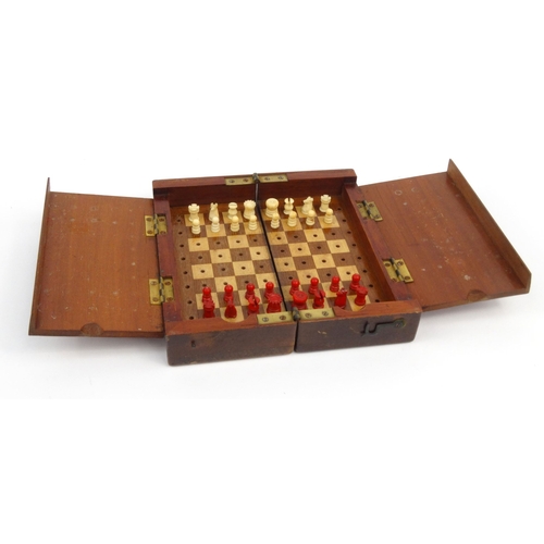 570 - Mahogany folding travelling boxed chess set, 18cm square