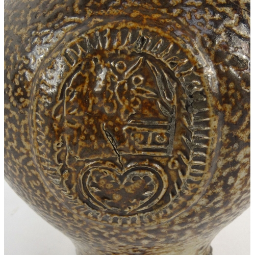 735 - Antique stoneware bellarmine with mask spout, 22cm high
