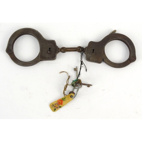 28 - Set of American cast iron handcuffs, The Peerless Handcuff Co, Springfield, Mass, C.O.CO, numbered 4... 