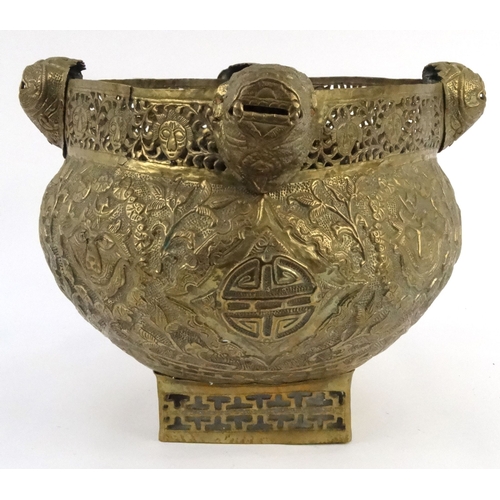 579 - Large oriental pierced brass pot with dragon finials and masks, 29cm high