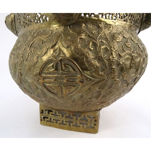 579 - Large oriental pierced brass pot with dragon finials and masks, 29cm high