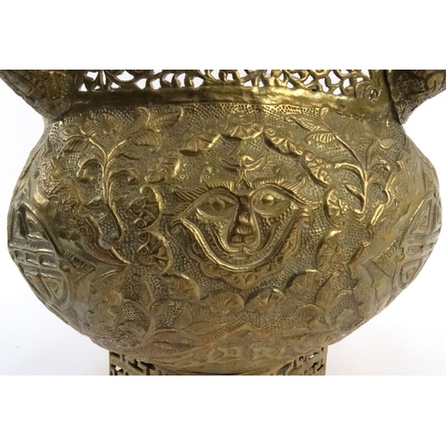 579 - Large oriental pierced brass pot with dragon finials and masks, 29cm high