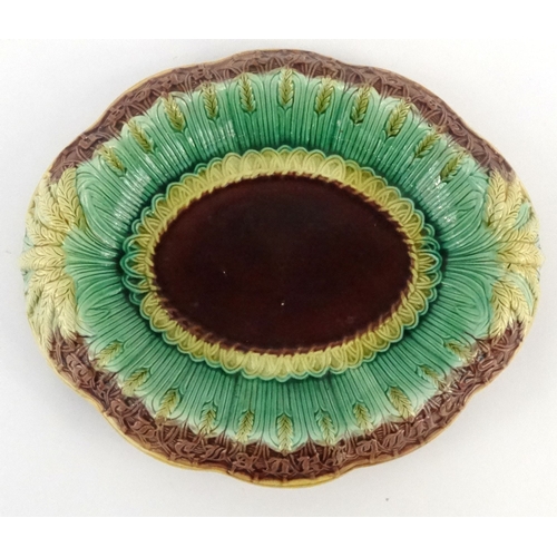711 - Victorian Majolica pottery bread plate decorated with wheatsheaves and script, 32cm diameter