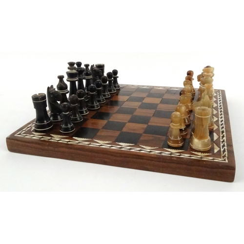 571 - Hardwood mother of pearl inlaid chess board with carved horn chess pieces, the largest piece 8cm hig... 