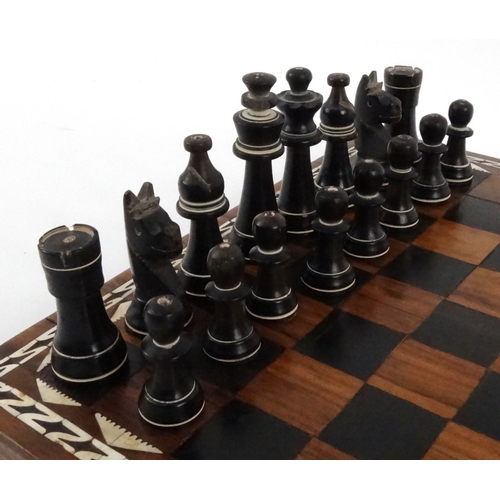 571 - Hardwood mother of pearl inlaid chess board with carved horn chess pieces, the largest piece 8cm hig... 