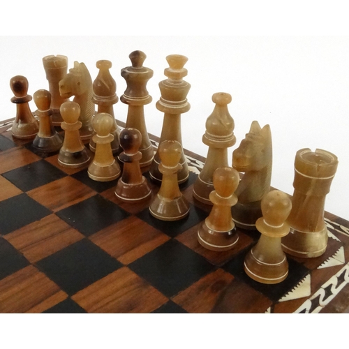 571 - Hardwood mother of pearl inlaid chess board with carved horn chess pieces, the largest piece 8cm hig... 