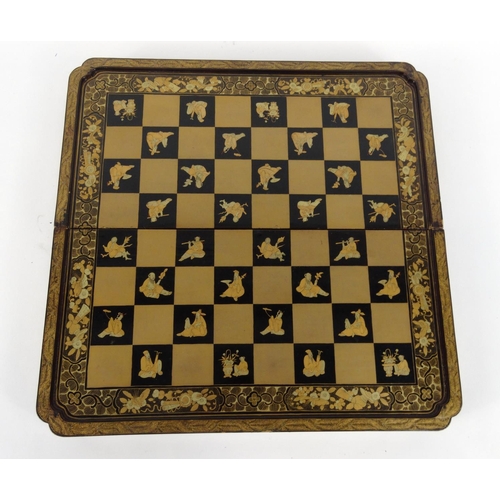 604 - Oriental chinese carved ivory chess set together with a folding black lacquered chess/backgammon boa... 