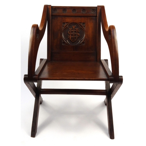 46 - Carved pitch pine X-framed occasional chair, 88cm high