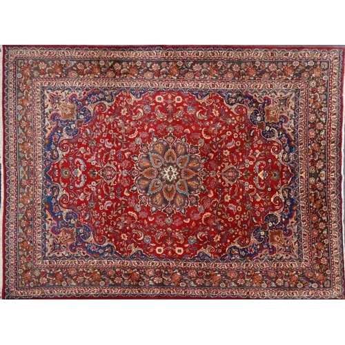 19 - Large red ground floral carpet with label 'Made in Iran', approximately 3.9m x 3m