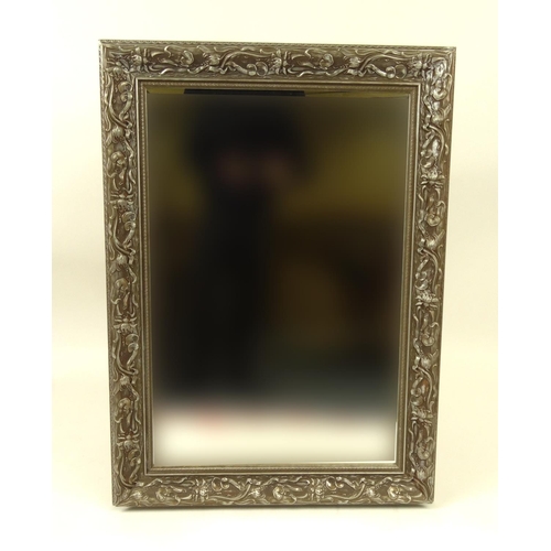 60 - Ornate silvered bevel edged mirror with floral frame, 108cm x 78cm