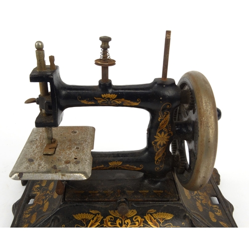143 - Victorian cast iron sewing machine with gilt Art Nouveau floral design, 28cm diameter