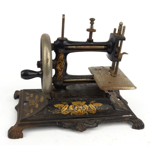 143 - Victorian cast iron sewing machine with gilt Art Nouveau floral design, 28cm diameter