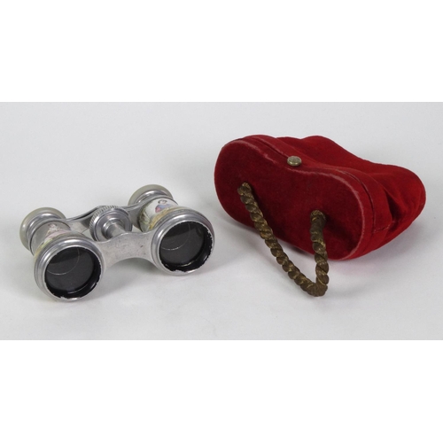 201 - Pair of opera glasses hand painted with lovers, housed in a red velvet case, 10cm long