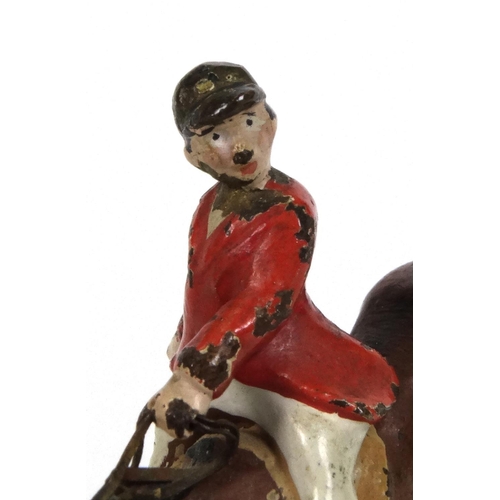 596 - Cold painted bronze model of a huntsman on horseback jumping over a fence, 5cm high