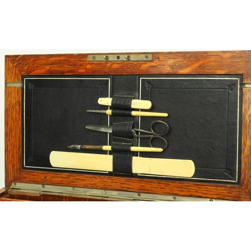 69 - Edwardian brass bound stationery box fitted with two cut glass ink bottles and an assortment of stat... 