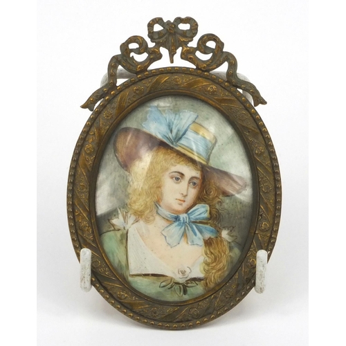 219 - Portrait miniature of a girl wearing a bonnet, housed in a brass swag design frame, 10cm high