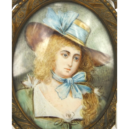 219 - Portrait miniature of a girl wearing a bonnet, housed in a brass swag design frame, 10cm high