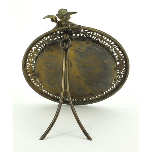 37 - Victorian pierced brass cherub easel framed mirror, 25cm diameter
