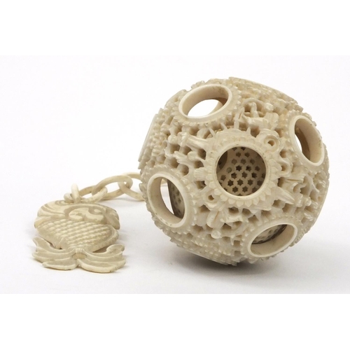 616 - Oriental Chinese puzzle ball on chain carved with figures and fish, 25cm long