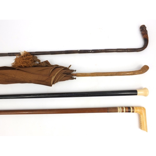 63 - Two ivory topped walking sticks, cane and a lady's silk parasol