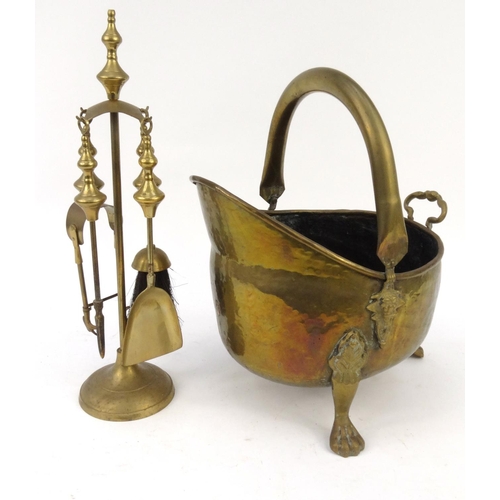 470 - Brass coal scuttle with paw feet and a brass companion set