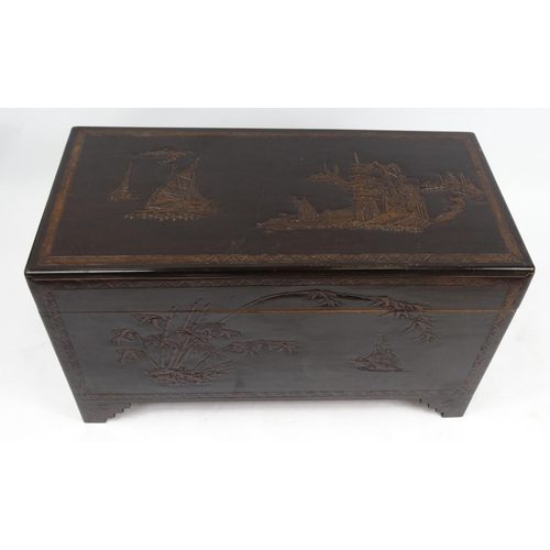 18 - Camphor wood chest carved with oriental scenes, 59cm high x 104cm wide x 51cm deep