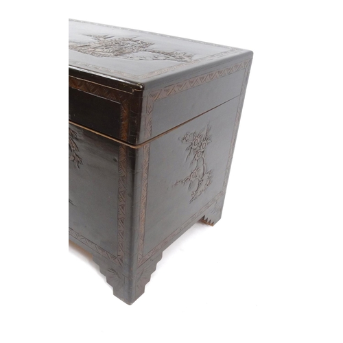 18 - Camphor wood chest carved with oriental scenes, 59cm high x 104cm wide x 51cm deep