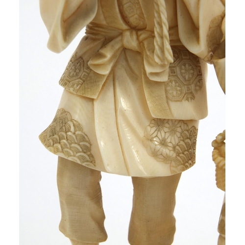 606 - Oriental Japanese ivory figure group of a fisherman carrying a basket of fish and a young boy, red s... 
