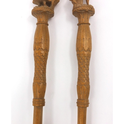 46 - Wooden spoon and fork carved with Continental style figures, each 29cm long