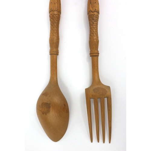 46 - Wooden spoon and fork carved with Continental style figures, each 29cm long