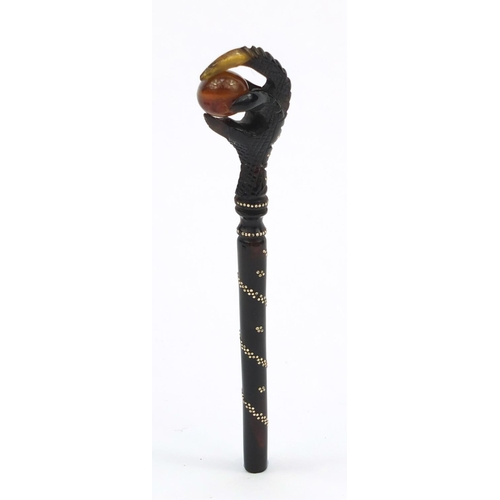 106 - Two tortoiseshell effect claw and ball seals, together with a similar example all inlaid with gold m... 