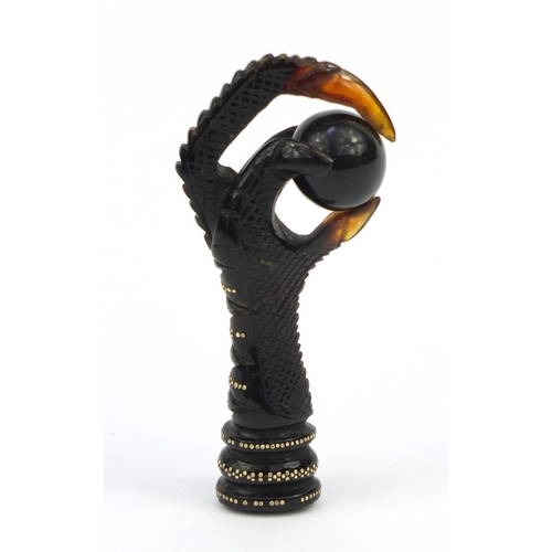 106 - Two tortoiseshell effect claw and ball seals, together with a similar example all inlaid with gold m... 