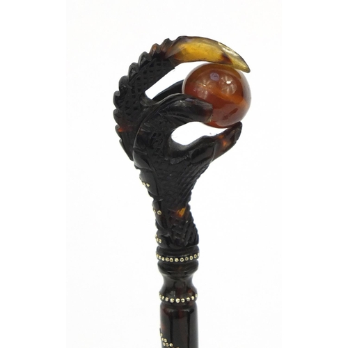 106 - Two tortoiseshell effect claw and ball seals, together with a similar example all inlaid with gold m... 