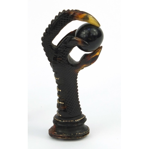 106 - Two tortoiseshell effect claw and ball seals, together with a similar example all inlaid with gold m... 