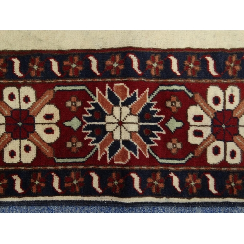 2060 - Rectangular Middle Eastern Qalin rug decorated with a geometric floral border onto a red and cream g... 