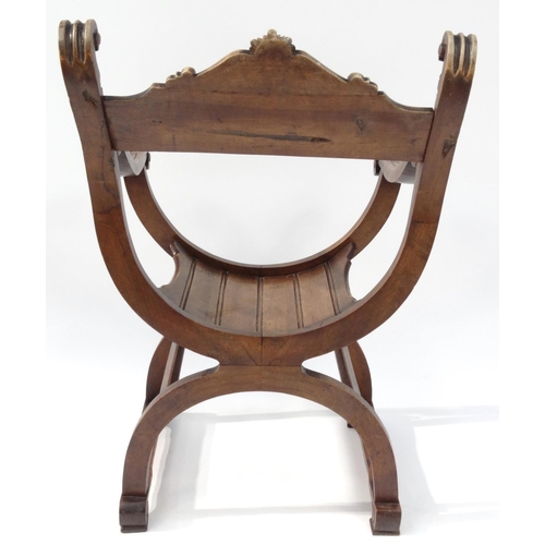 2034 - Carved wooden X-framed chair with face finials, 85cm high