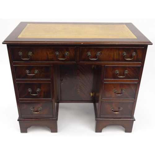 2020 - Mahogany kneehole desk with tooled leather insert top and fitted with eight drawers, 76cm high x 93c... 