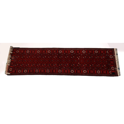 14 - Red ground geometric patterned carpet runner, approximately 300cm x 82cm