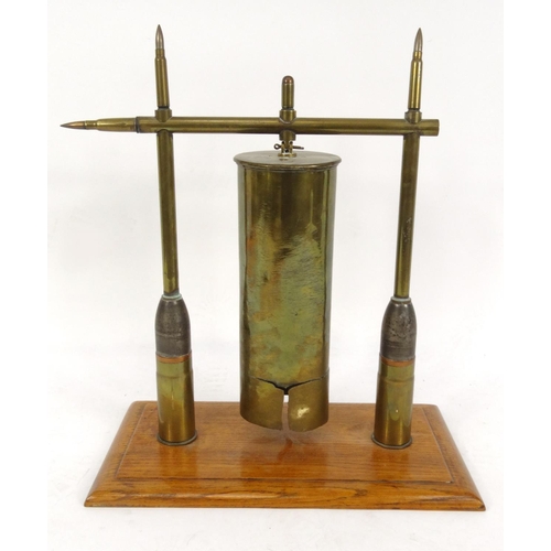 750 - Military interest trench art table gong raised on an oak plinth, 44cm high