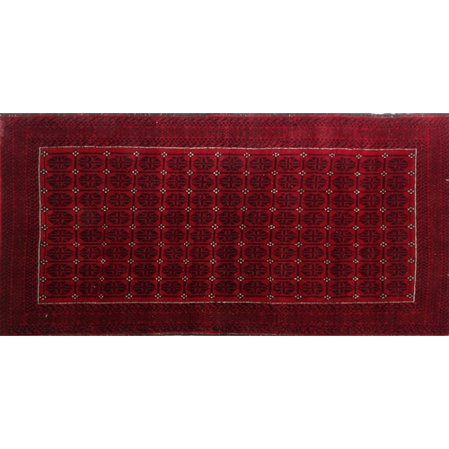 38 - Red and black ground geometric patterned rug, 206cm x 106cm