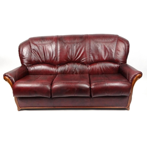 31 - Mahogany framed burgundy leather three seater settee and two armchairs
